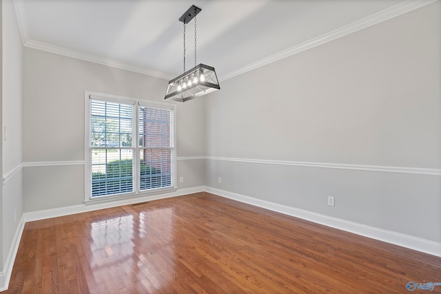 unfurnished dining area with wood-type flooring, crown molding, and a notable chandelier