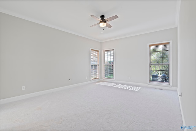 carpeted spare room featuring crown molding and ceiling fan