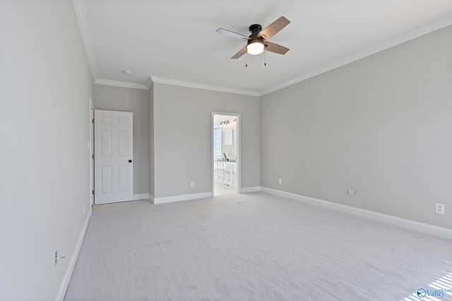 empty room featuring ceiling fan, crown molding, and light carpet