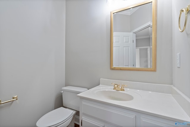 bathroom with vanity, toilet, and crown molding