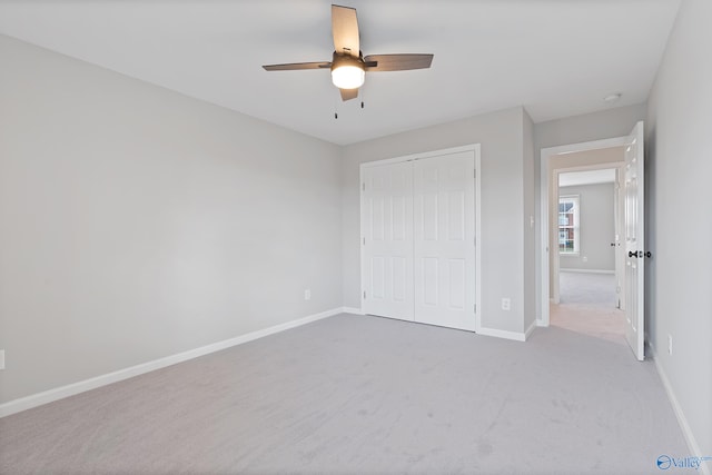 unfurnished bedroom with light carpet, a closet, and ceiling fan