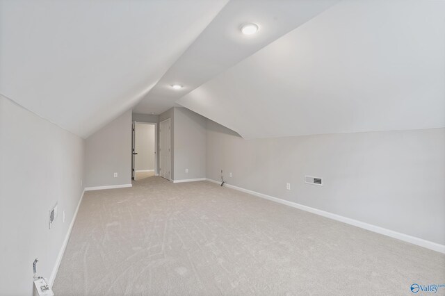 additional living space featuring light carpet and lofted ceiling