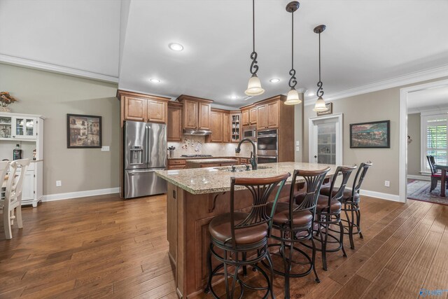 39 Verdant Cir, Huntsville, AL 35803 - kitchen featuring stainless steel appliances, brown cabinetry, recessed lighting, a kitchen breakfast bar, and light stone counters
