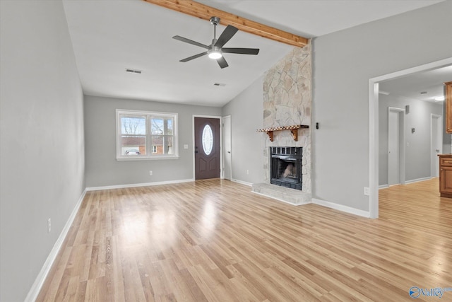 unfurnished living room featuring a fireplace, light wood-type flooring, vaulted ceiling with beams, and ceiling fan