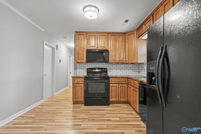 kitchen featuring black appliances, light hardwood / wood-style floors, ornamental molding, and tasteful backsplash