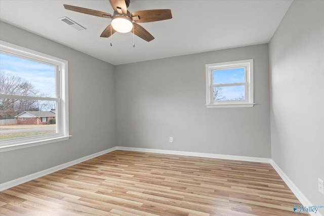 unfurnished room with light hardwood / wood-style floors, a wealth of natural light, and ceiling fan