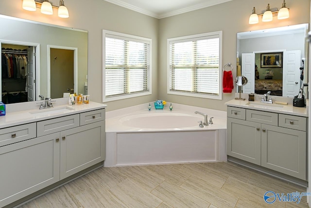 bathroom featuring vanity, crown molding, and a tub