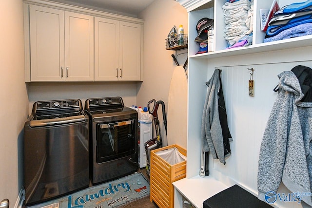 laundry room with washing machine and clothes dryer and cabinets