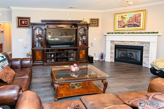 living room featuring crown molding, a stone fireplace, and dark hardwood / wood-style flooring