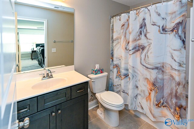 bathroom featuring vanity, toilet, a shower with shower curtain, and tile patterned flooring