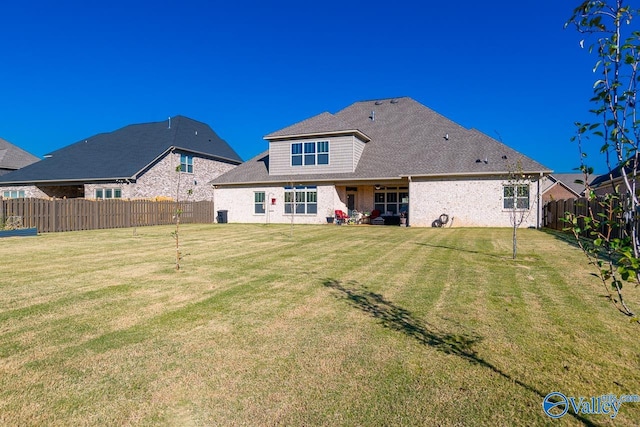 rear view of house featuring a lawn