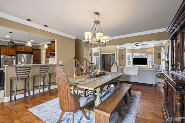 dining room featuring dark wood finished floors, ceiling fan with notable chandelier, stairs, and ornamental molding