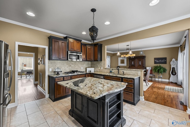 kitchen with ornamental molding, a peninsula, stainless steel appliances, and a sink