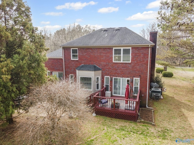 back of property with roof with shingles, a wooden deck, a yard, a chimney, and brick siding