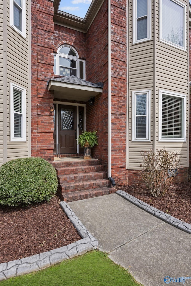 property entrance featuring brick siding