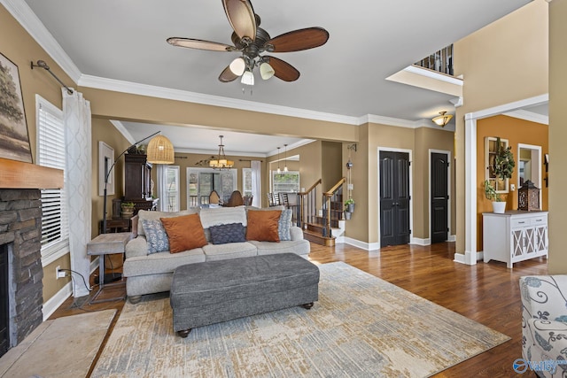 living area with wood finished floors, stairway, a fireplace, crown molding, and baseboards