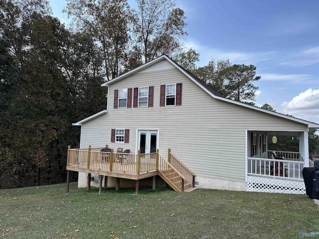 rear view of house featuring a deck, a lawn, and french doors