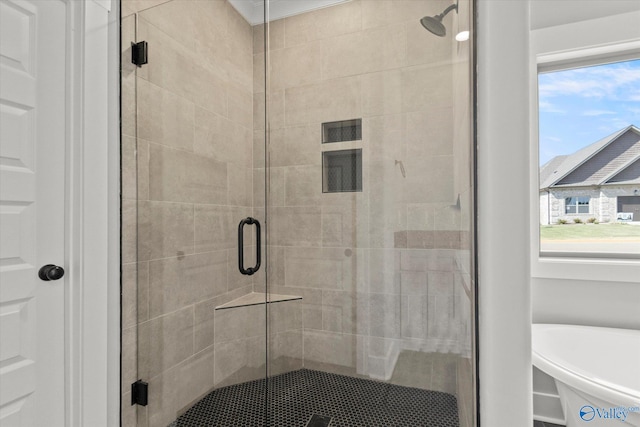 bathroom with a healthy amount of sunlight and independent shower and bath