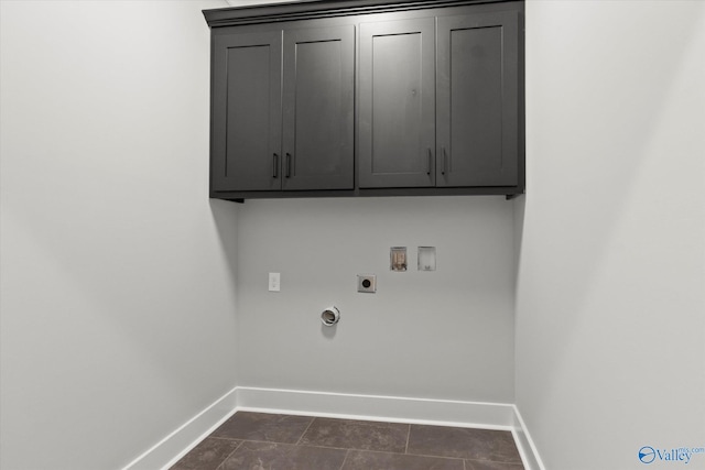 washroom with dark tile patterned flooring, hookup for a washing machine, cabinets, and electric dryer hookup