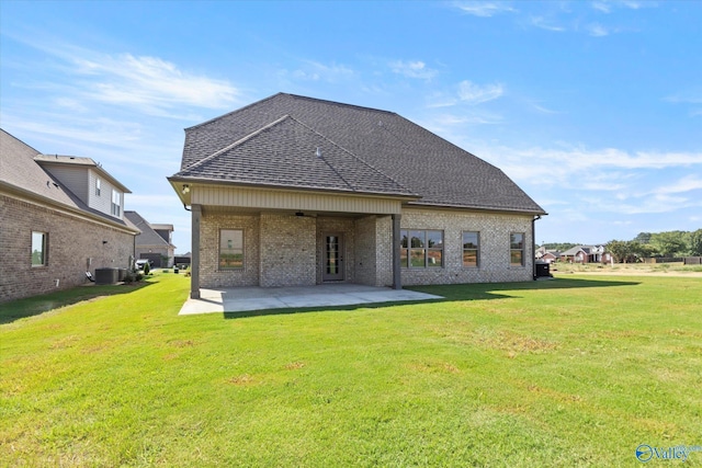 back of property with a yard, a patio, and central air condition unit