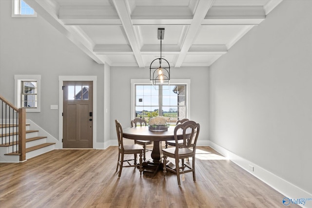 dining room with coffered ceiling, wood-type flooring, an inviting chandelier, and beam ceiling