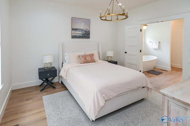 bedroom featuring baseboards, an inviting chandelier, and light wood-style flooring