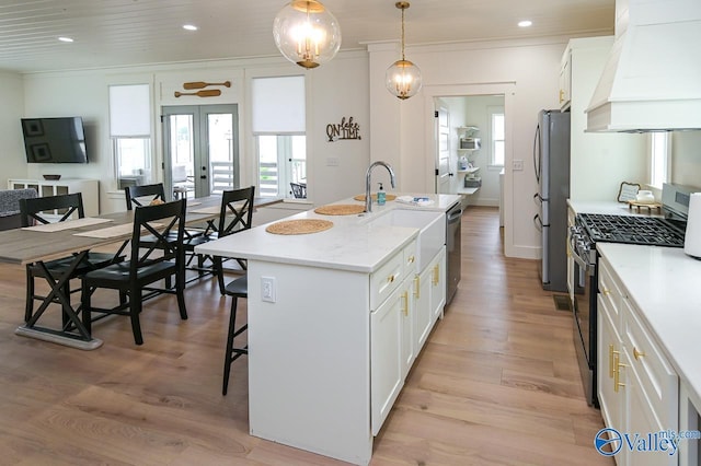 kitchen with white cabinets, a breakfast bar area, custom exhaust hood, appliances with stainless steel finishes, and ornamental molding