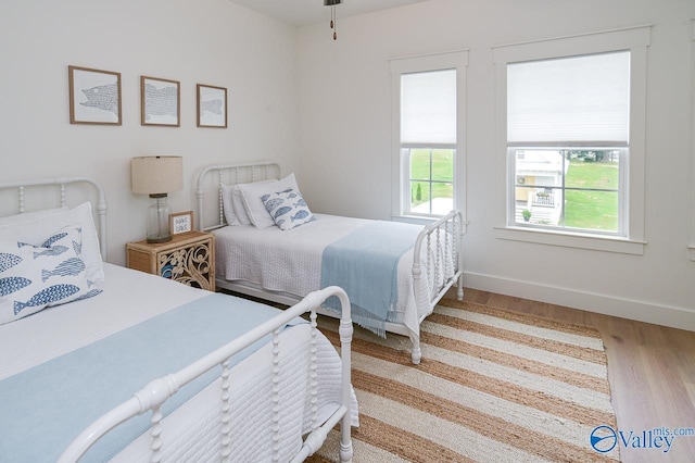 bedroom featuring baseboards and wood finished floors