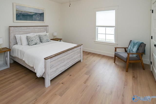 bedroom featuring light wood-type flooring and baseboards