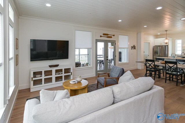 living area featuring french doors, wood finished floors, recessed lighting, and ornamental molding