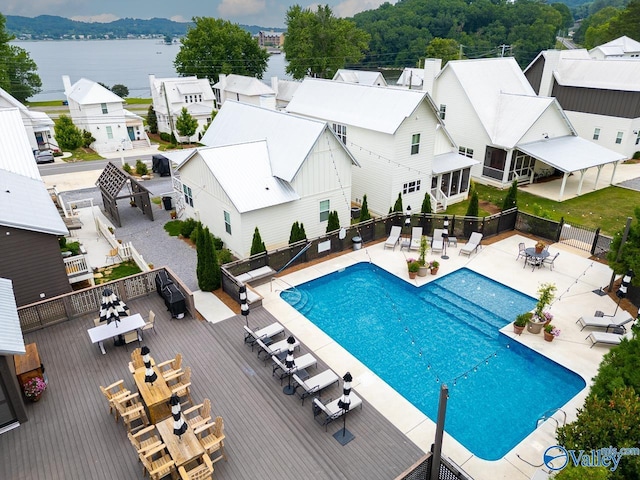 pool featuring a residential view, a deck with water view, and fence