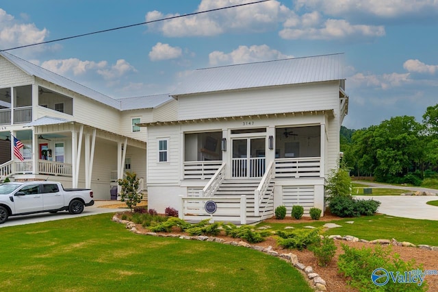 bungalow-style home featuring stairway, ceiling fan, a front lawn, and a sunroom