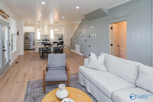 living area featuring light wood-type flooring, baseboards, visible vents, recessed lighting, and stairway