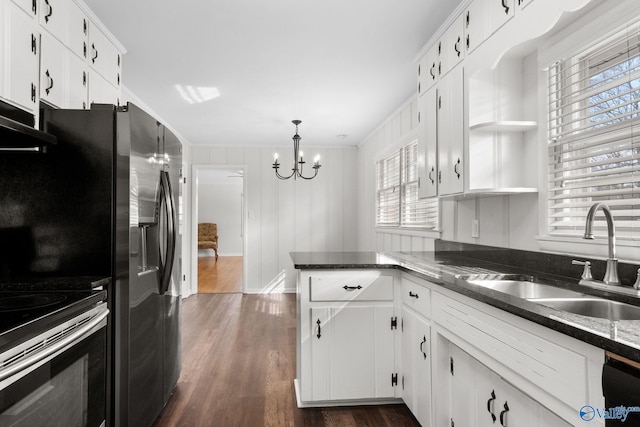 kitchen featuring dark wood finished floors, open shelves, white cabinetry, a sink, and dark stone countertops