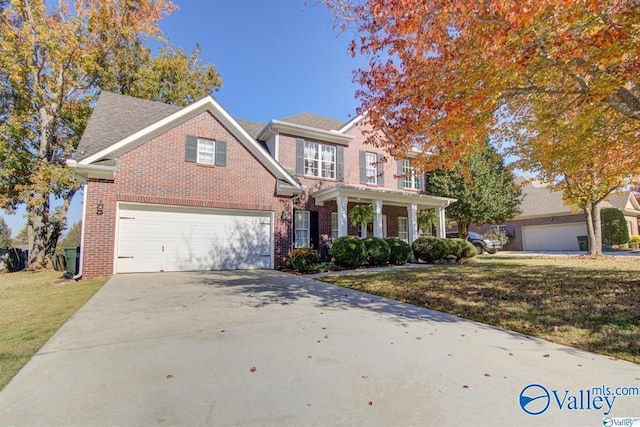 view of front of property featuring brick siding, a front yard, and concrete driveway