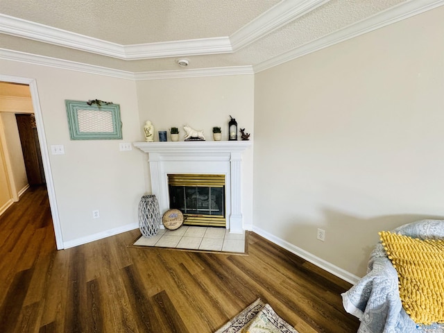 living area with a textured ceiling, baseboards, a tiled fireplace, and wood finished floors