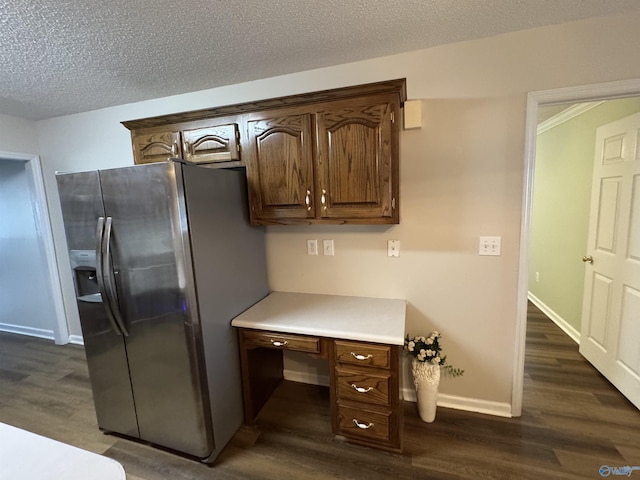 kitchen featuring light countertops, dark wood-type flooring, stainless steel refrigerator with ice dispenser, and built in study area