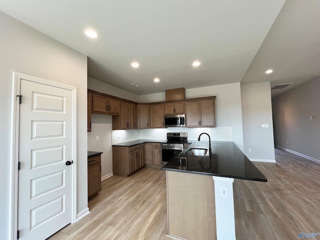 120 Parvin Way Dr, Hazel Green, AL 35750 - kitchen featuring light wood finished floors, a sink, dark countertops, and appliances with stainless steel finishes