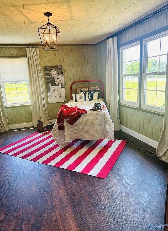2010 Youngs Chapel Rd, Piedmont, AL 36272 - bedroom featuring wood finished floors, a chandelier, baseboards, and wood walls