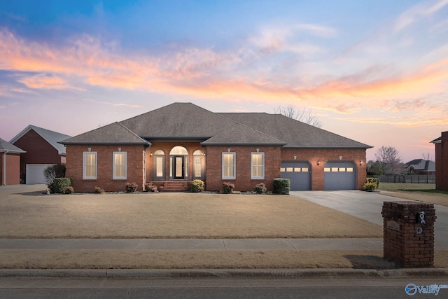 view of front of home with an attached garage, brick siding, a shingled roof, fence, and driveway