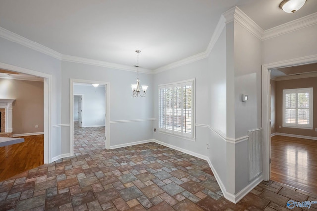 unfurnished dining area with a fireplace with raised hearth, stone tile floors, a notable chandelier, and a healthy amount of sunlight