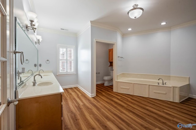 bathroom with visible vents, toilet, wood finished floors, crown molding, and a sink