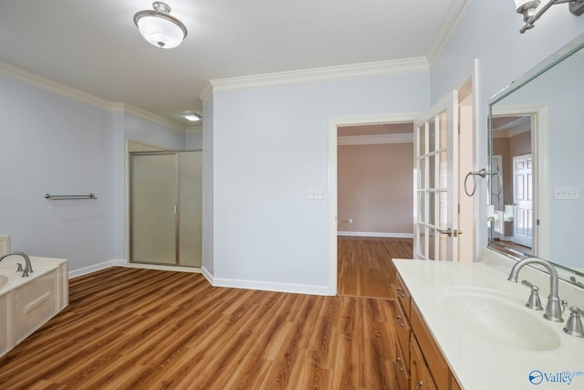 full bath featuring wood finished floors, a shower stall, vanity, and crown molding