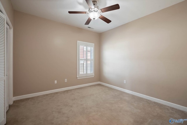 unfurnished bedroom featuring light carpet, a ceiling fan, visible vents, baseboards, and a closet