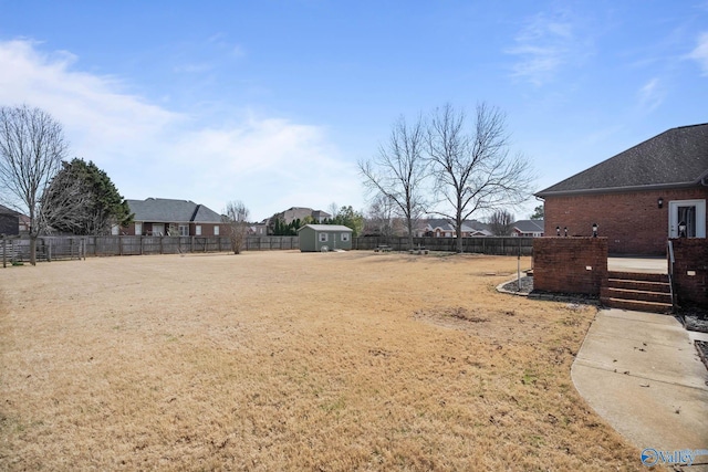 view of yard featuring a fenced backyard, an outdoor structure, and a shed