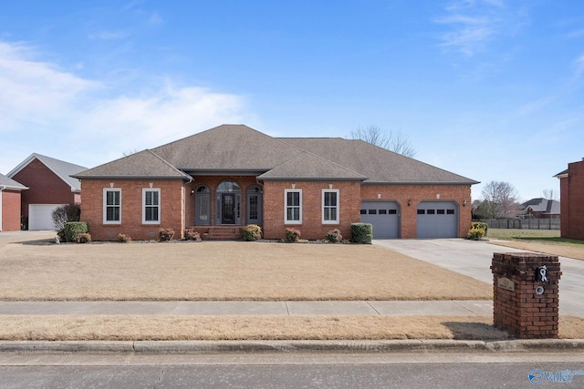 view of front facade featuring a garage, driveway, brick siding, and roof with shingles