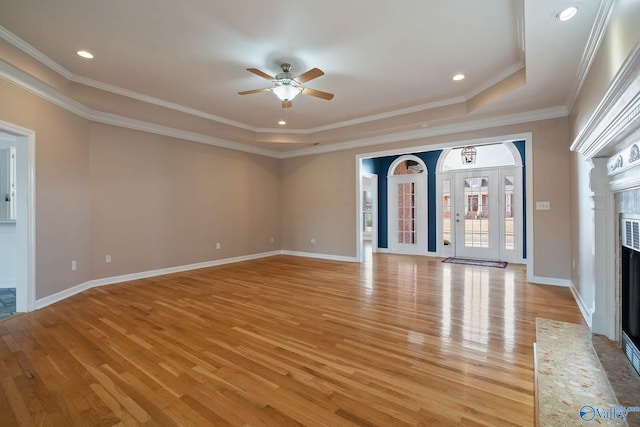 unfurnished living room featuring a fireplace with flush hearth, a ceiling fan, light wood-style floors, ornamental molding, and baseboards