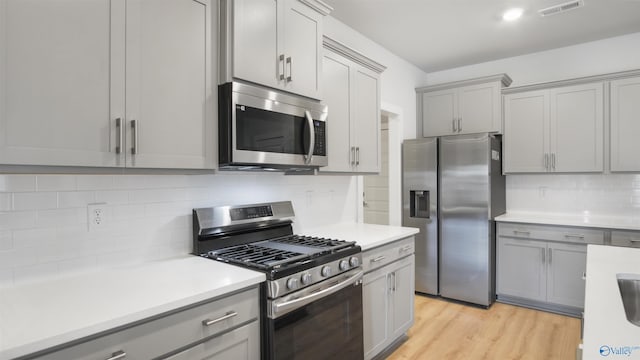 14801 Demarie Ln, Athens, AL 35611 - kitchen featuring appliances with stainless steel finishes, gray cabinets, tasteful backsplash, and light countertops