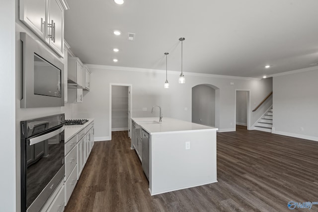 kitchen featuring dark wood-type flooring, light countertops, appliances with stainless steel finishes, and crown molding