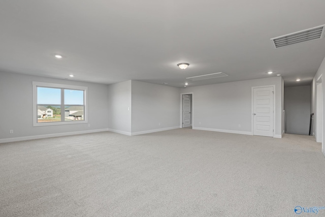 empty room featuring visible vents, baseboards, recessed lighting, and light carpet